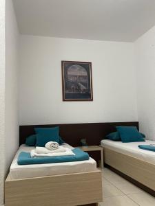 斯韦蒂·斯特凡蒙特佩拉公寓的客房配有两张带蓝色枕头的床。