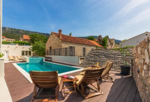 波尔Bol Summer Residence的一个带桌椅的庭院和一个游泳池