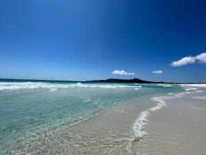 卡波布里奥Éolos Loft's - Cabo Frio的一片拥有大海和蓝天的海滩