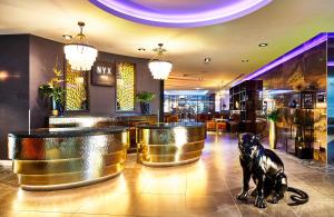 华沙NYX Hotel Warsaw by Leonardo Hotels的狗坐在餐厅的大堂