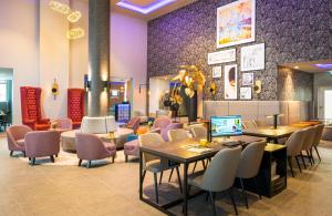 埃施伯恩Leonardo Hotel Eschborn Frankfurt的餐厅设有桌椅和紫色墙壁