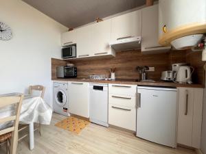 乌瑞基尼Appartement Urrugne, 2 pièces, 2 personnes - FR-1-239-508的厨房配有白色橱柜、洗衣机和烘干机
