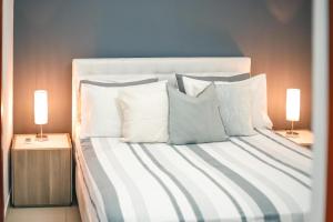 圣多明各ARMONIA 408 APARTMENT IN GAZCUE的一间卧室配有一张带白色枕头的床和两盏灯。