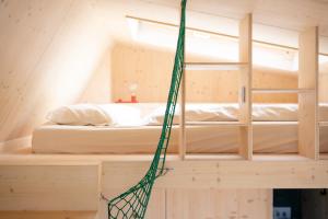 卡罗利嫩西尔Tiny House Pioneer 18 Zur Meerseite - Green Tiny Village Harlesiel的吊床挂在一张床的房间