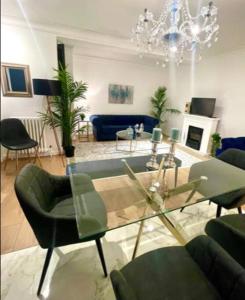 伦敦Luxury 3 bedroom 3 and a half bathroom flat in Swiss Cottage的客厅配有玻璃桌和椅子