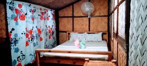 科隆Coron Backpacker Guesthouse的小房间,配有带窗帘的床