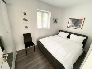 博尔什Maison Bellevue - 2 bdrm villa in Borsh beach的卧室配有一张白色大床和一把椅子