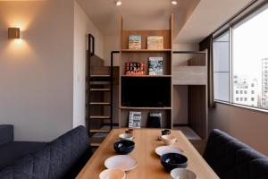东京COCOSHUKU Asakusa Kuramae的客厅配有木桌和电视。