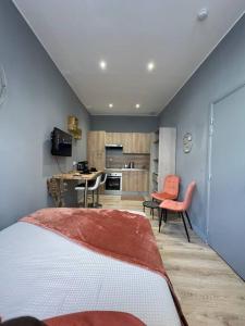 瓦朗西纳Studio Vieux Valenciennes的一间卧室配有一张床,厨房配有桌子