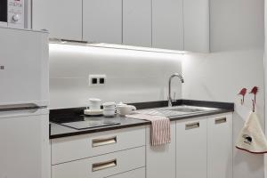 EaApartamentos Ea Astei的白色的厨房配有白色橱柜和水槽