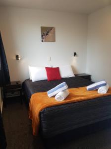 罗托鲁瓦全季假日公园酒店的一间卧室配有一张大床和毛巾