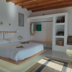 阿诺梅拉Teal Rock Mykonos的卧室配有一张白色大床和木制天花板