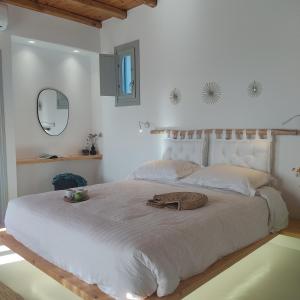 阿诺梅拉Teal Rock Mykonos的白色卧室设有一张大床和镜子