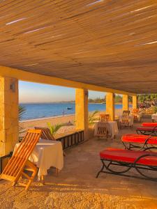 伊法地Ifaty Beach Club Resort的海滩上带桌椅的庭院