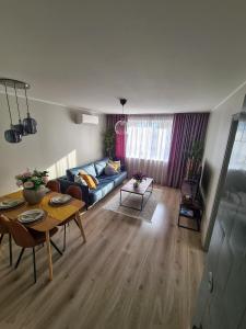 沃鲁Hubane Olevi Apartment的客厅配有蓝色的沙发和桌子