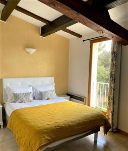 韦尔东的圣克鲁瓦auberge du castellas的一间卧室配有一张带黄色棉被的床和窗户