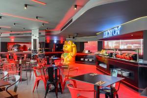 圣安东尼奥Hotel Vibra District - Adults Only的一间设有红色桌椅的餐厅和一间设有猫标的餐厅
