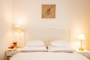 皮罗瓦茨Apartment Lolić Pirovac的一张白色的床,上面有两个枕头