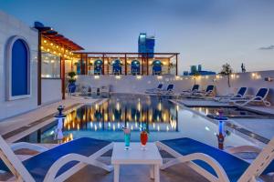 迪拜多纳泰罗酒店的一座游泳池,在大楼前的桌子上放着两杯饮料
