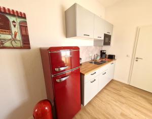 美因茨Burgunder - helle und geräumige Wohnung的白色橱柜厨房里的红色冰箱