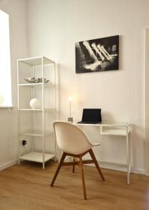 美因茨Burgunder - helle und geräumige Wohnung的一张桌子,一张笔记本电脑和一把椅子放在房间里
