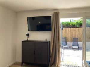 滨海萨纳里Villa Célina Accessible PMR的客厅设有壁挂式平面电视。