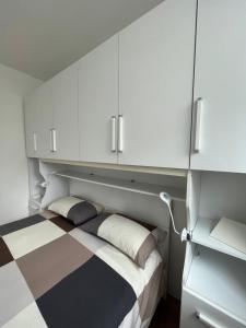 米兰The Small White House In Milan的一间卧室配有一张带白色橱柜的床。
