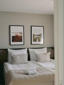 SiljansnäsSiljansnäs Hotell的卧室配有一张墙上有两张照片的床。