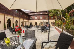 普雷代亚尔Voila Inn Predeal的庭院配有带遮阳伞和椅子的桌子