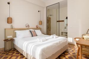 罗德镇Casa Natura的卧室配有一张白色大床和一张书桌