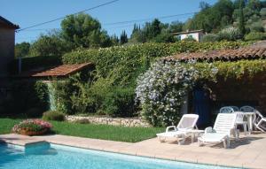 奥皮约拉特里尼泰度假屋的一个带椅子的游泳池,一个种满鲜花的树 ⁇ 