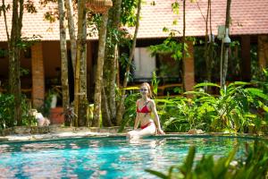 富国Valley Village Phu Quoc的坐在游泳池里的比基尼女人