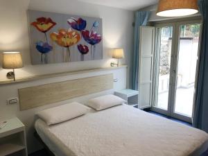 马拉泰亚2 bedrooms house at Maratea 50 m away from the beach with sea view enclosed garden and wifi的一间卧室设有一张床,墙上设有鲜花窗户。