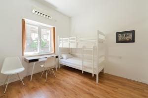 尼什Sleep Hostel的一间卧室设有两张双层床、一张桌子和一扇窗户。