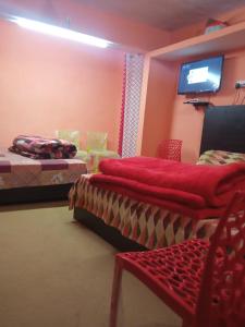 乔斯希马特Badri Kedar Hometay的客房设有两张床和一台平面电视。
