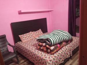 乔斯希马特Badri Kedar Hometay的粉红色的卧室配有带枕头和椅子的床