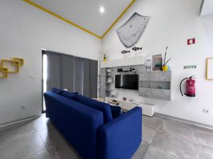 Faja GrandeSpot Milasmar的客厅配有蓝色的沙发和电视