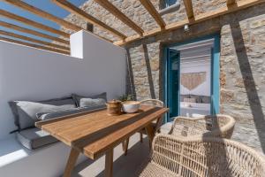 阿格拉瑞Anemela Villas & Suites Mykonos的一张木桌和椅子,位于一个配有沙发的房间