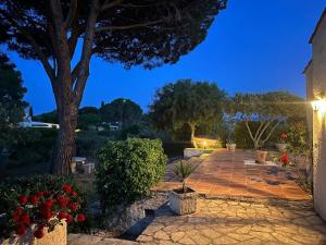 格里莫Villa-Golfe de Saint-Tropez/Accès plage privée的花木繁盛的夜晚花园