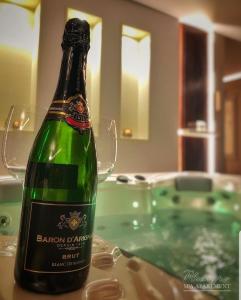 诺维萨德Spa Pleasure Apartman的浴缸旁的桌子上摆放着一瓶香槟