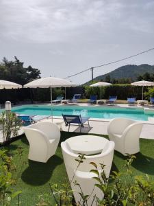 卡尔德杜Natur Hotel Tanca的一个带白色桌椅的游泳池和一个游泳池