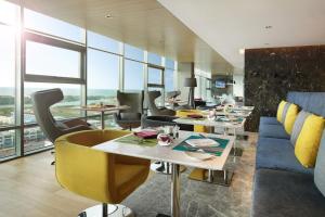 马六甲Noble Resort Hotel Melaka的大型客房设有桌椅和窗户。