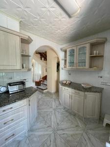 艾姆布里亚布拉瓦Leones的一间设有白色橱柜和瓷砖地板的大厨房