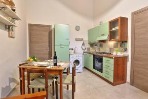 阿沃拉Casa Francesca的厨房配有桌子和绿色冰箱。
