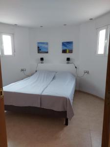 阿尔考斯布里Villa Tranquila的白色客房的一张床位,设有两个窗户