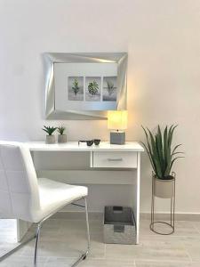康托卡利Elia Room & Garden II (new entry)的一张带椅子和镜子的白色书桌