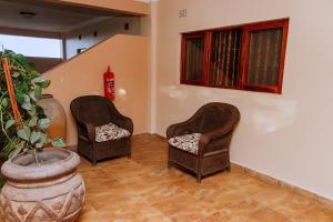 KitweShamba Lodge的一间有盆栽的房间里,有两把椅子