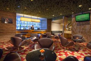 香港香港百乐酒店的一间设有椅子的等候室和一间带电视的酒吧