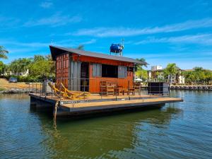 巴西利亚House Boat "Faroeste Caboclo"的水面上的一个橘色房子