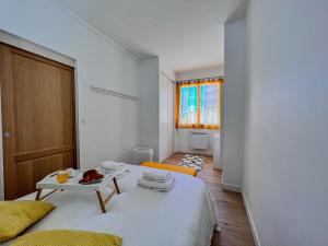 鲁西隆地区卡内Appartement vue mer Parking privé Place Med的卧室配有一张白色的床,上面放着一盘食物